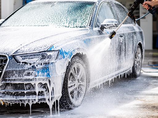 Lavado exterior de un coche urbano con espuma y agua a presión en Sevilla